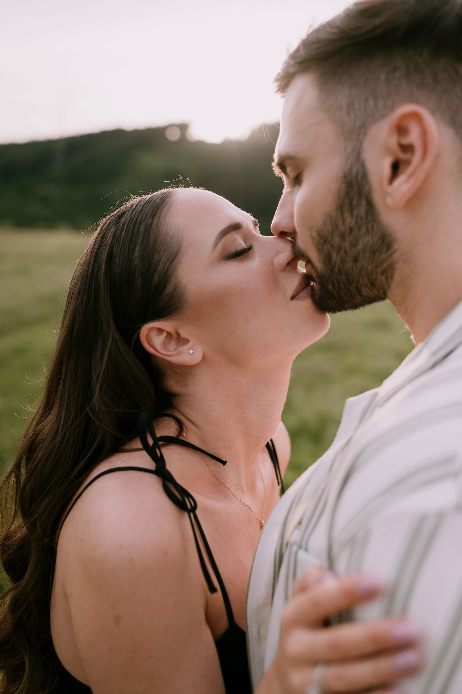 Intimate couple embracing and sharing romantic moments against a natural outdoor backdrop.
