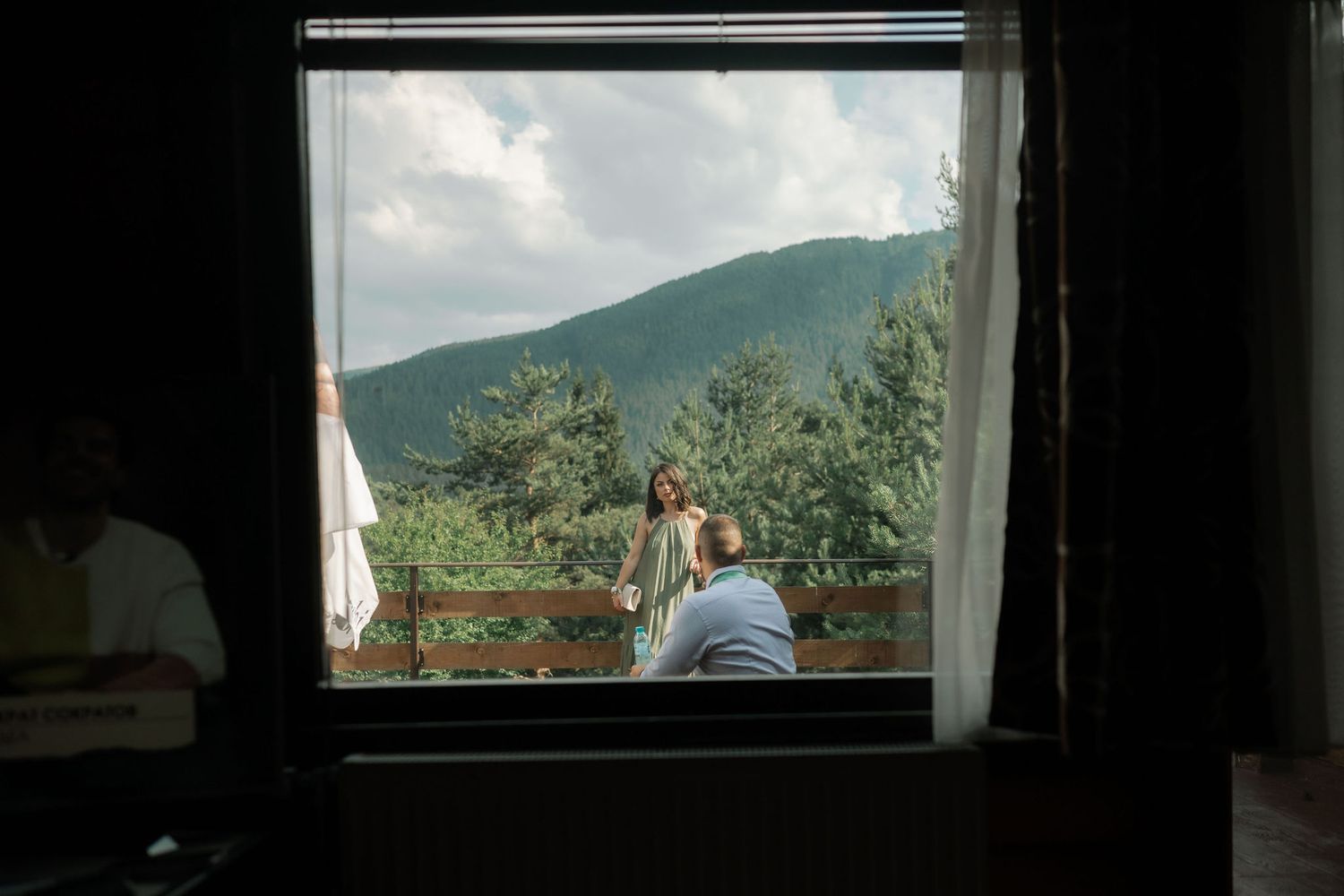 Four window frames showing scenic mountain and forest views through glass panes in sequence.