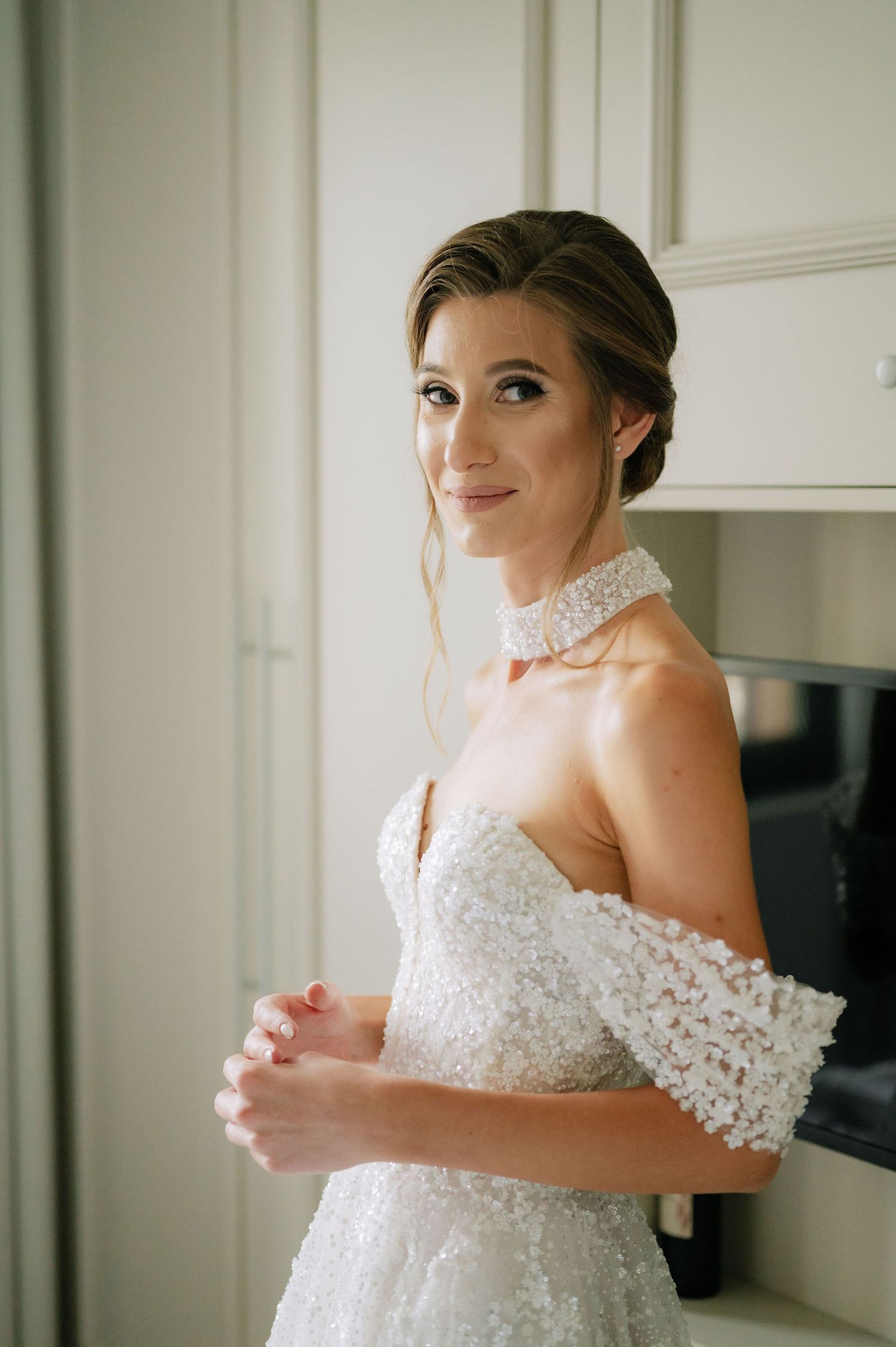 Elegant bridal portrait showing intricate lace details of a white wedding gown.