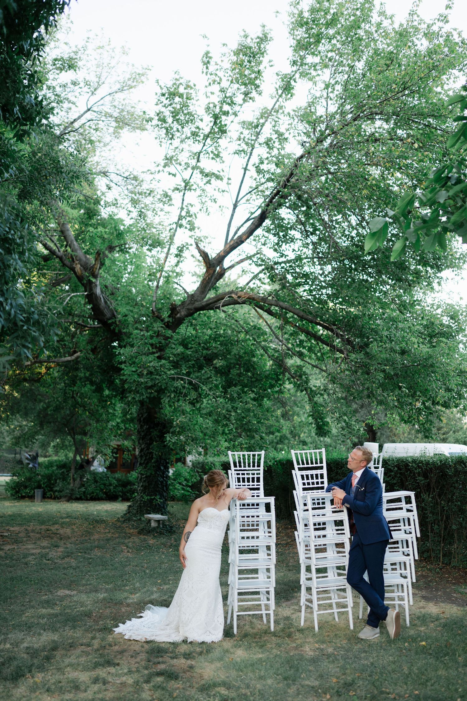A couple dances between rows of white chairs at an outdoor wedding venue.