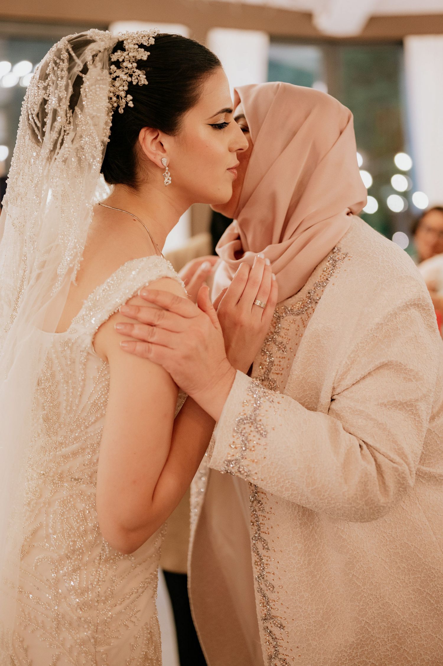 Intimate wedding moment captured in soft indoor lighting.