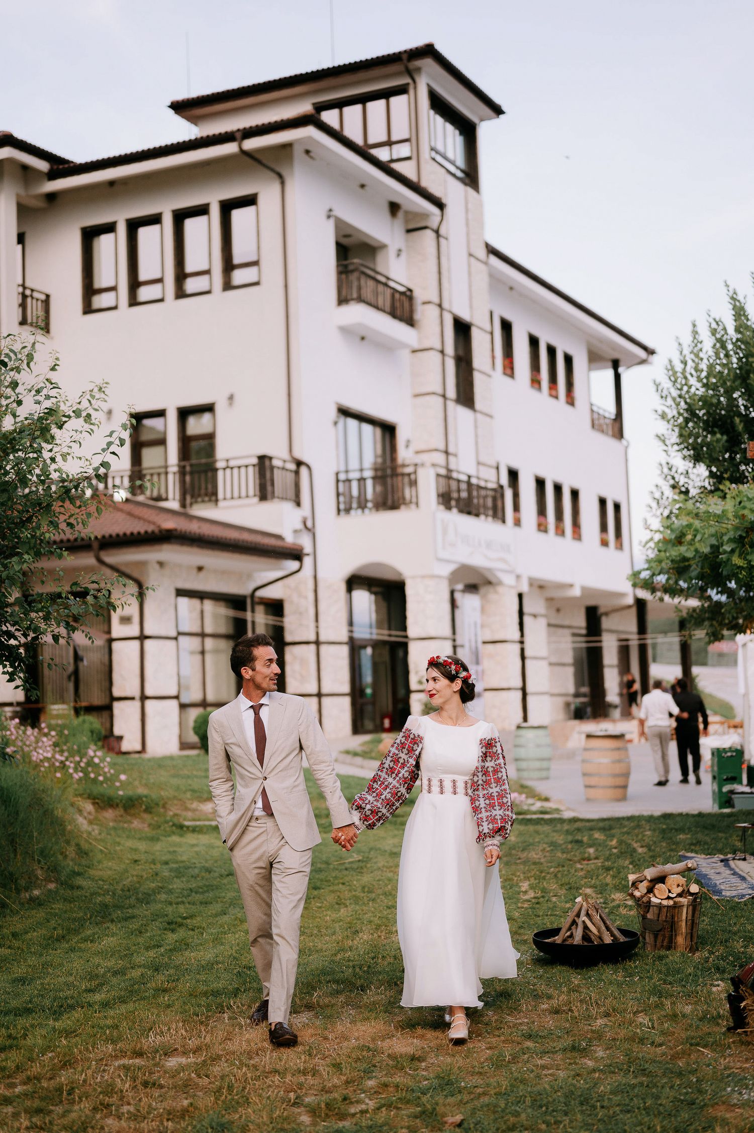 Romantic celebration outside a Mediterranean-style building with rustic outdoor decorations.