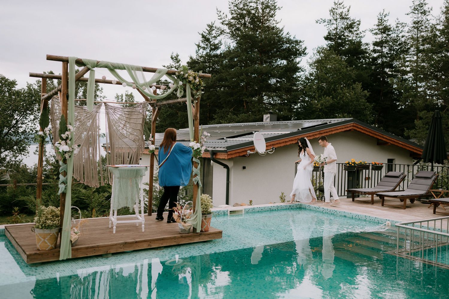 Swimming pool with wooden deck and mountain landscape in background.