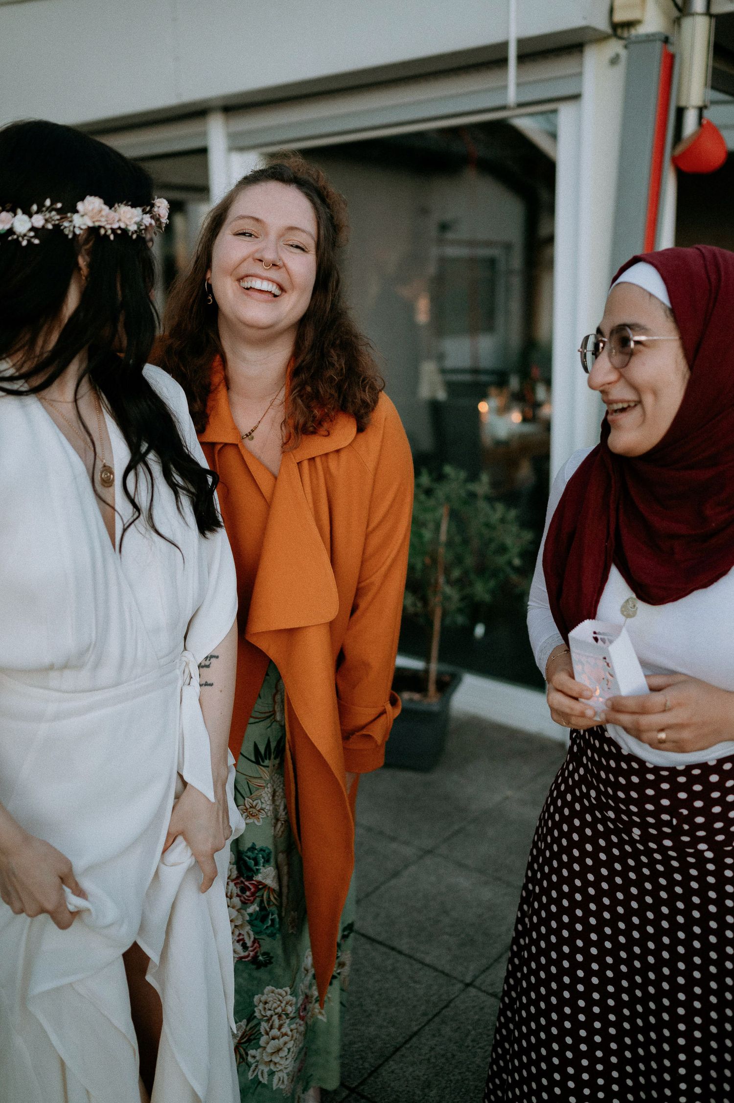 A group wearing white and orange outfits sharing joyful moments together outdoors.