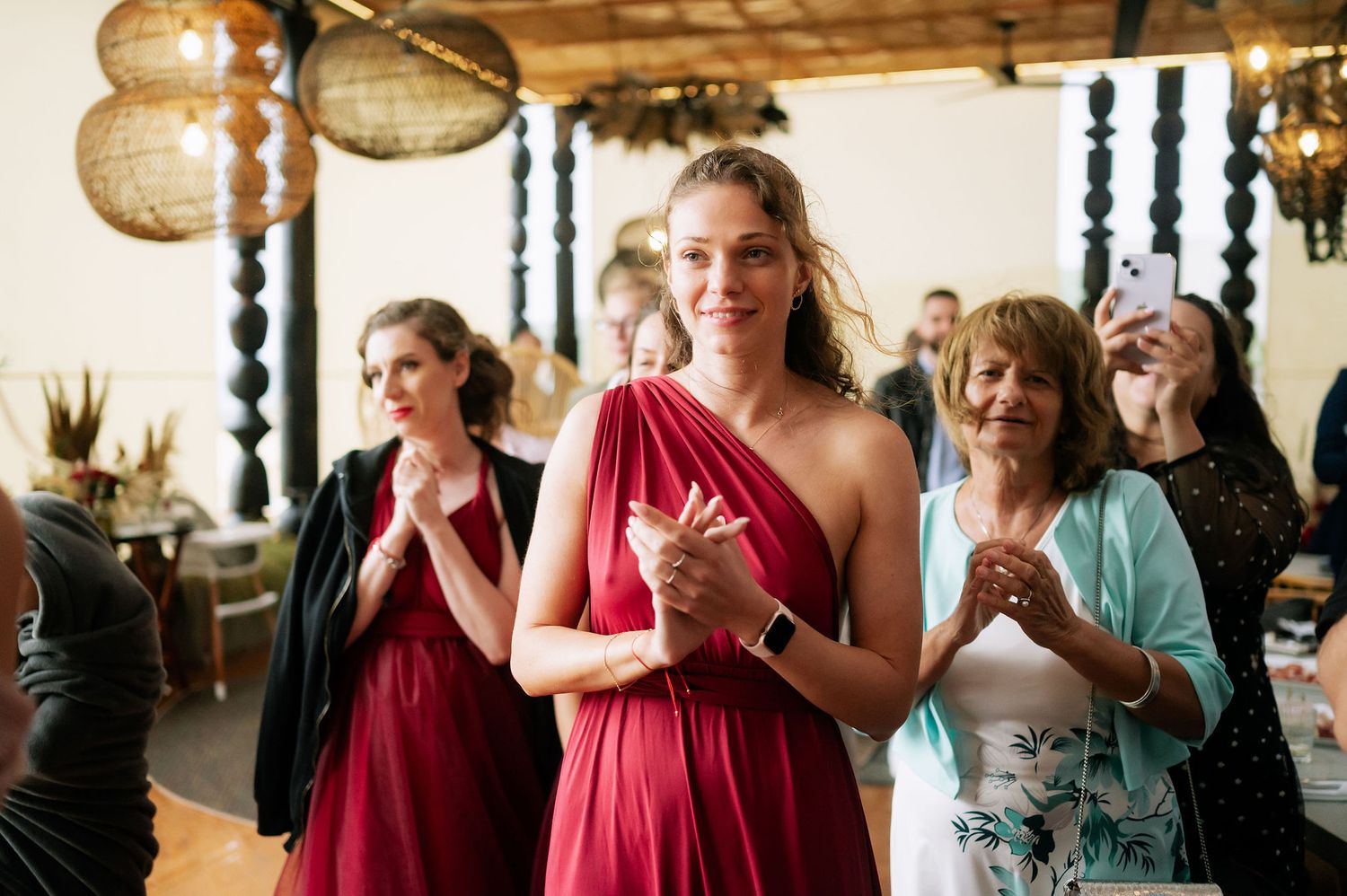 Wedding celebration with bridesmaids in burgundy dresses and elegant indoor decor.