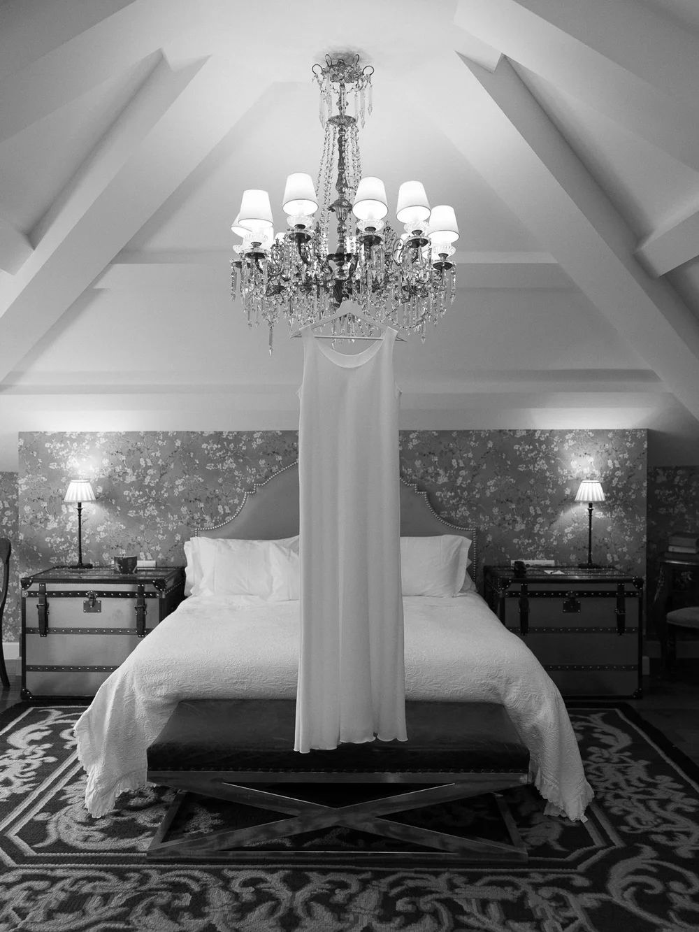 Elegant black and white hotel room series featuring crystal chandeliers, white bedding, and vaulted ceilings.