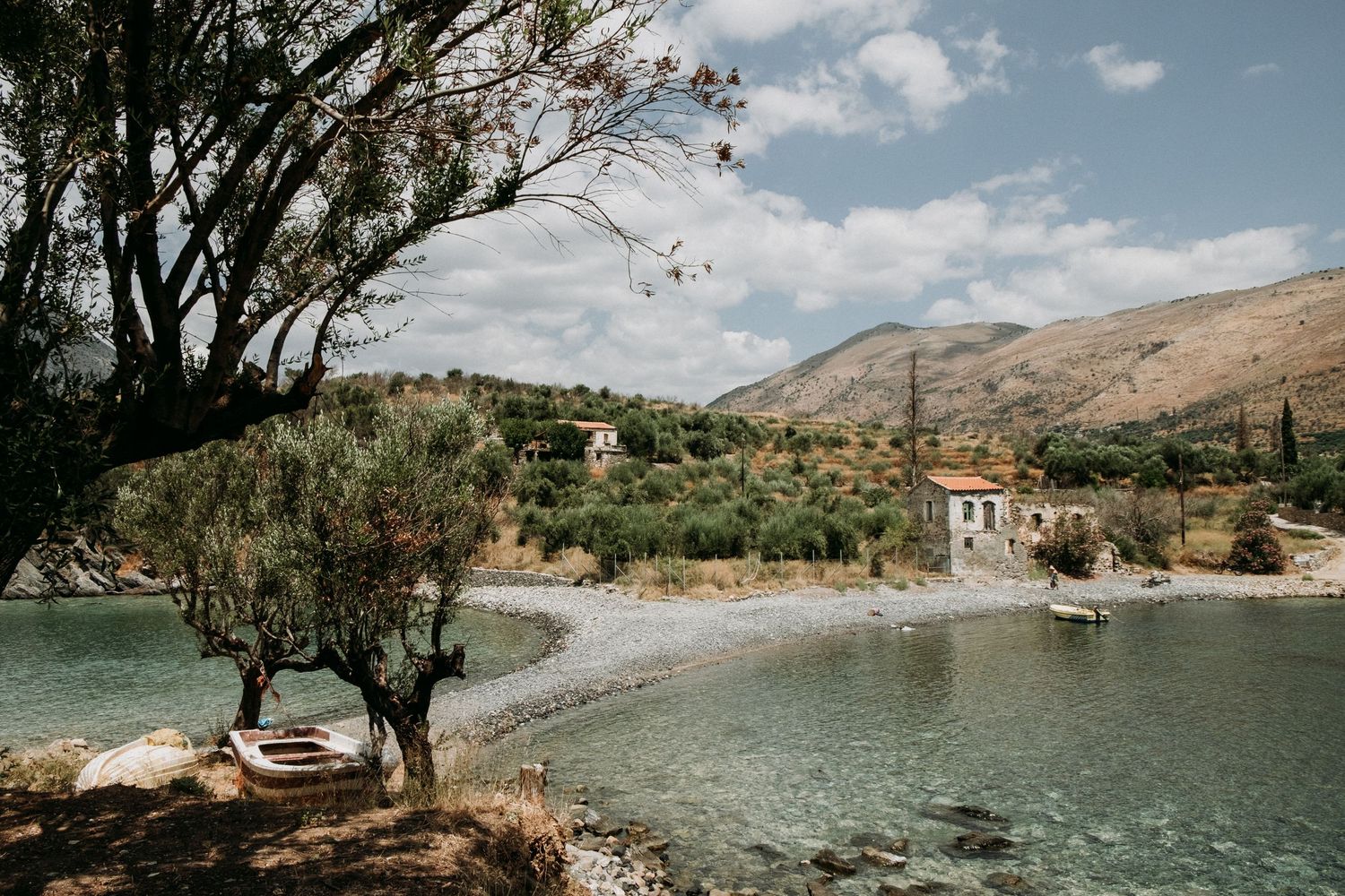 Beautiful Mediterranean coastline with mountains, trees, and crystal clear waters.