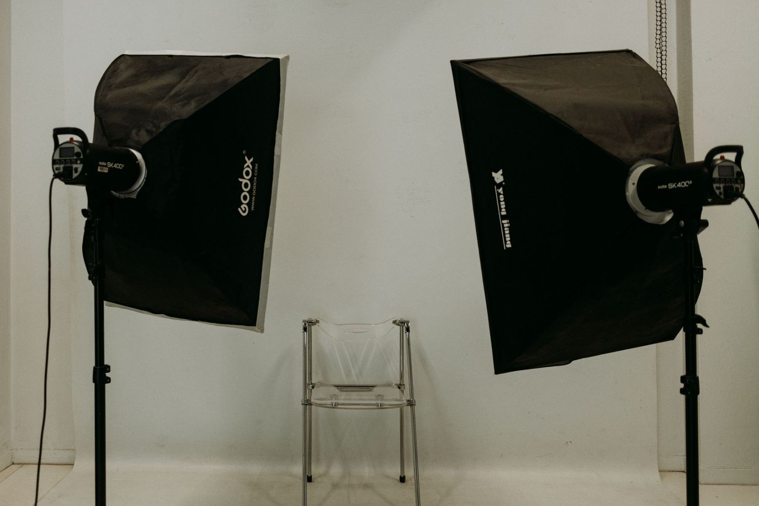 Professional photography studio setup with white backdrop and lighting equipment.