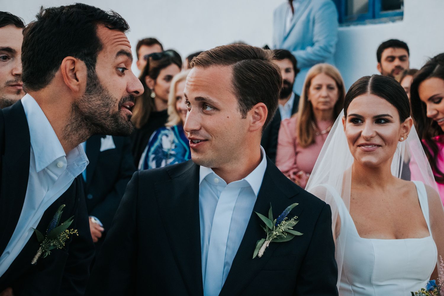 Candid moment during a wedding celebration with guests in formal attire.