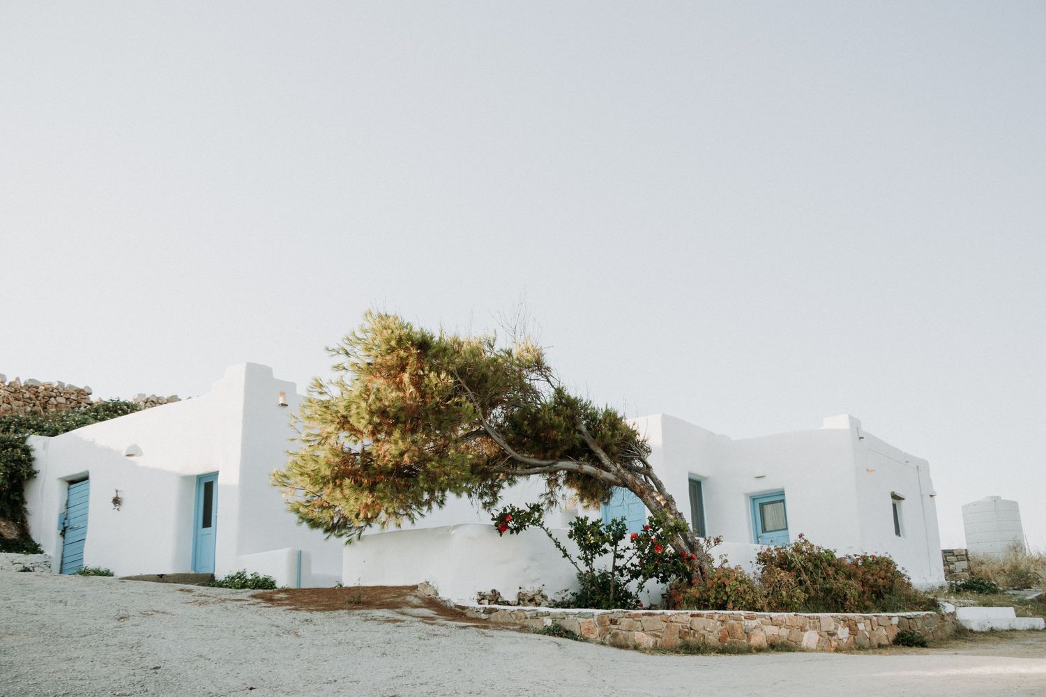 White Mediterranean style buildings with blue trim against clear sky.