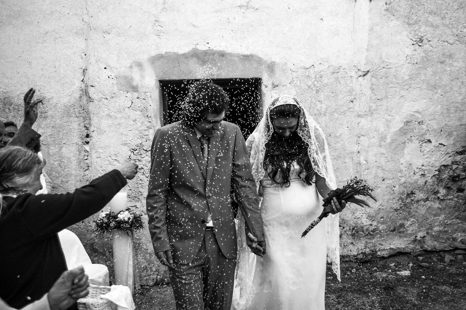 Black and white wedding photography series against textured stone walls.