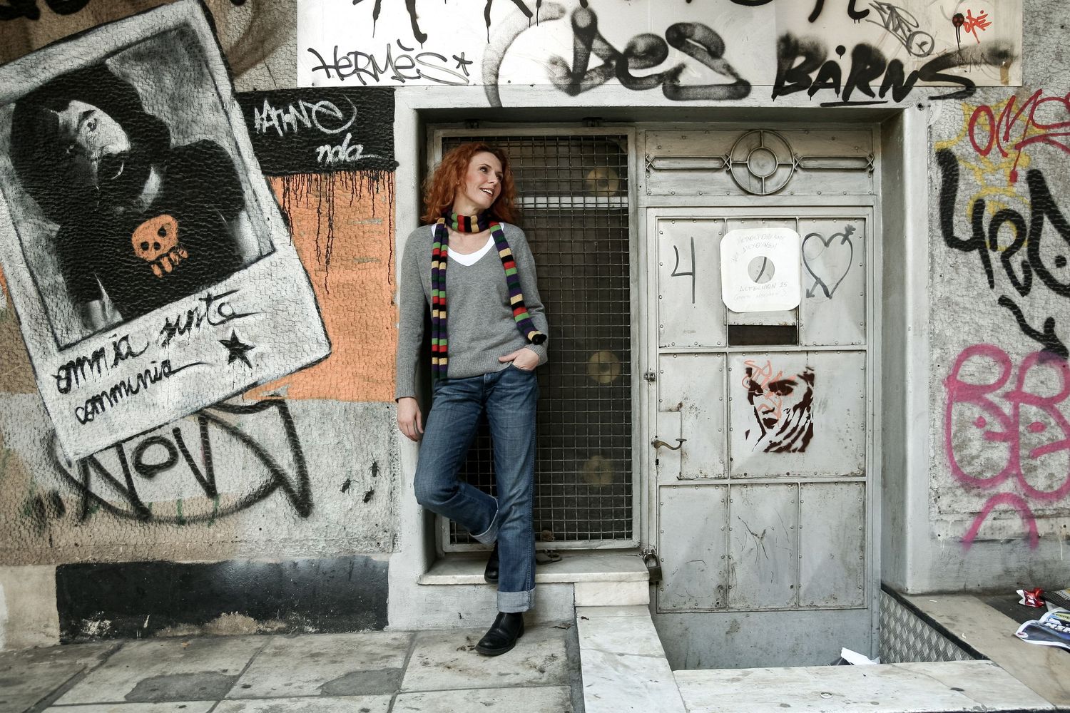 Urban street art and graffiti covers walls and doors along a gritty city alleyway.