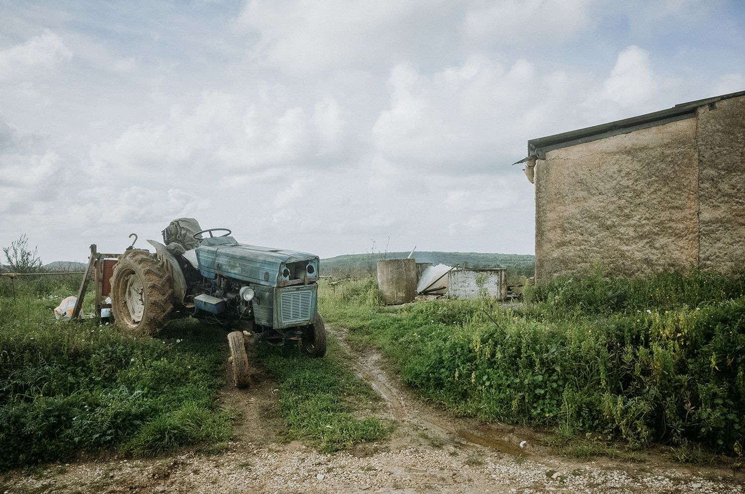 A panoramic view of a rural farm landscape with fields, buildings, and crops stretching across the horizon.