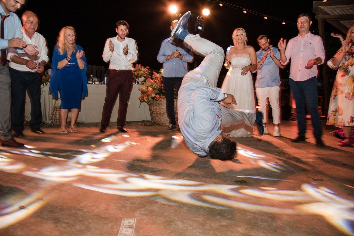 Wedding reception dance floor with guests dancing under warm lighting.
