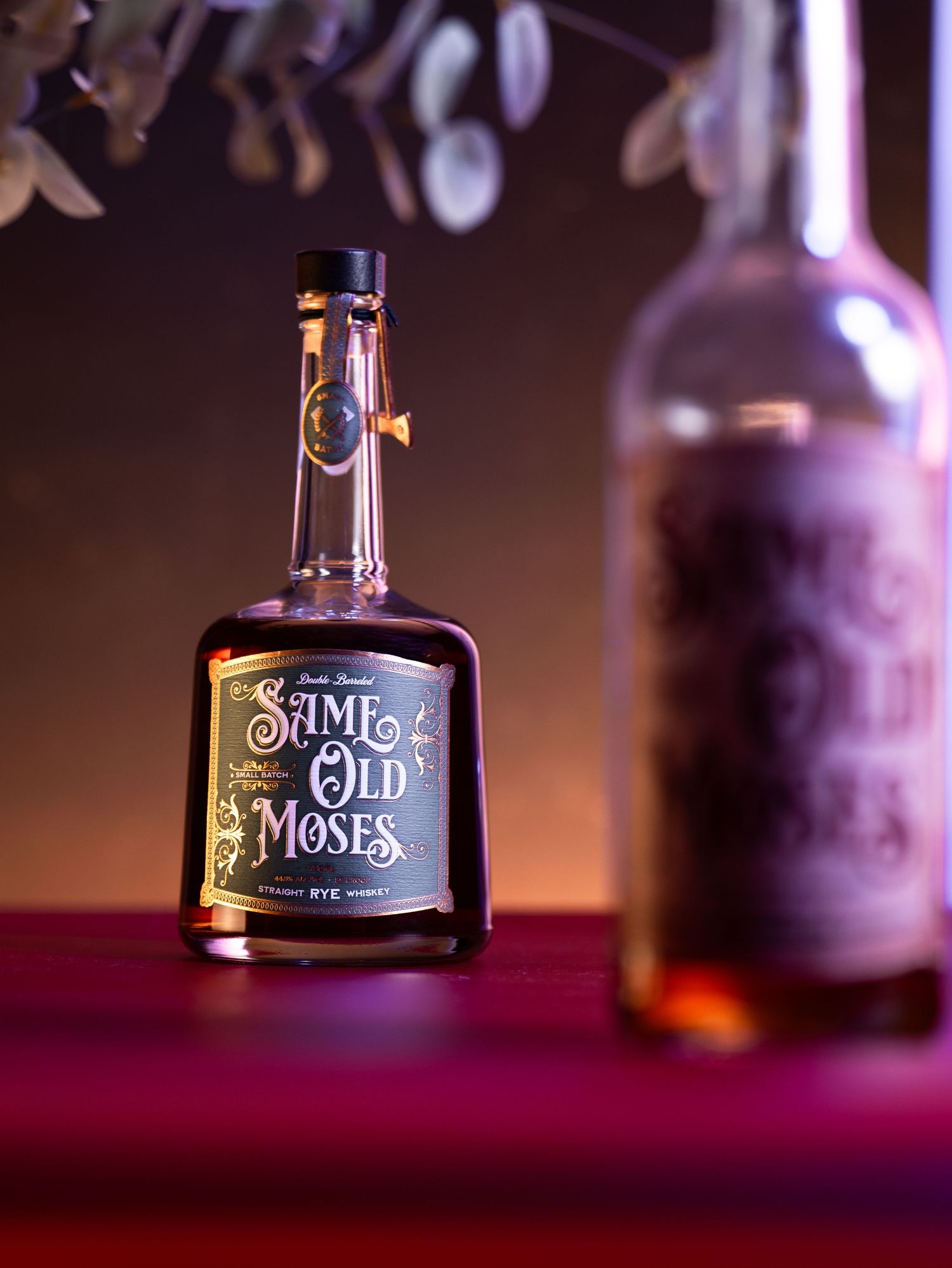 Close-up shot of Moses bourbon whiskey bottle with dark background and dramatic lighting.