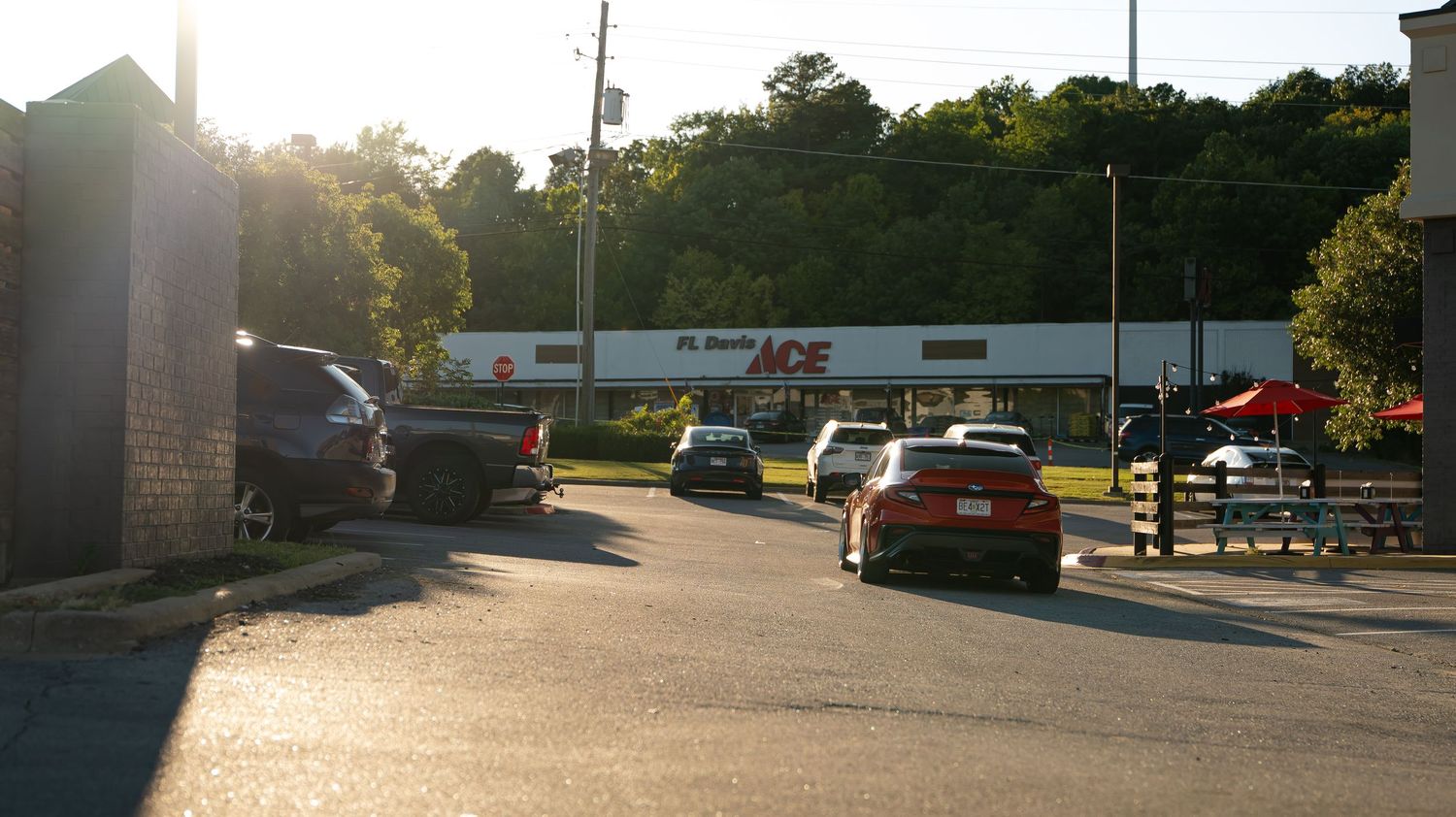 Panoramic sunset view of a shopping center parking lot.