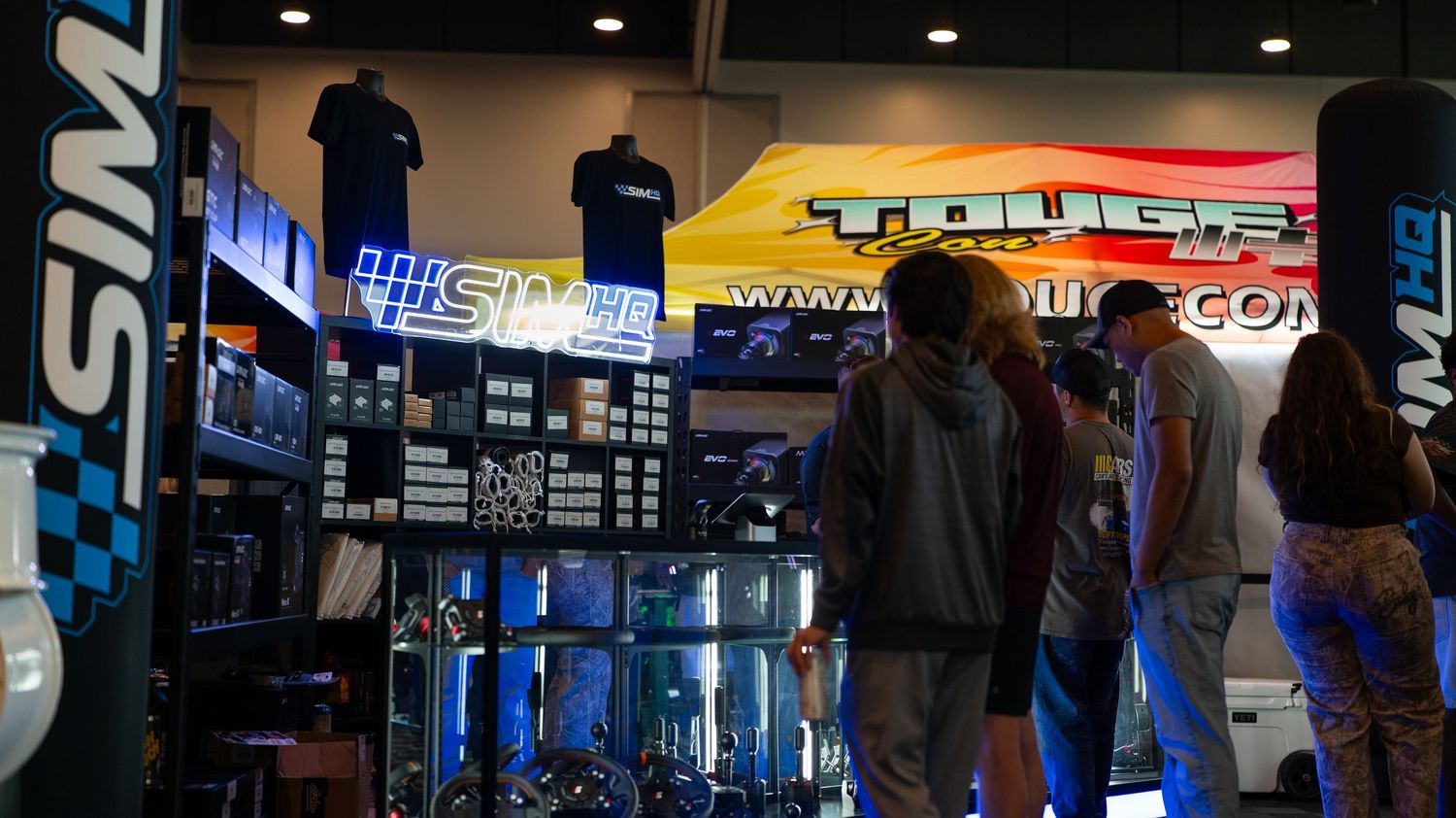 Wide view of a gaming convention hall with illuminated vendor displays and signage.