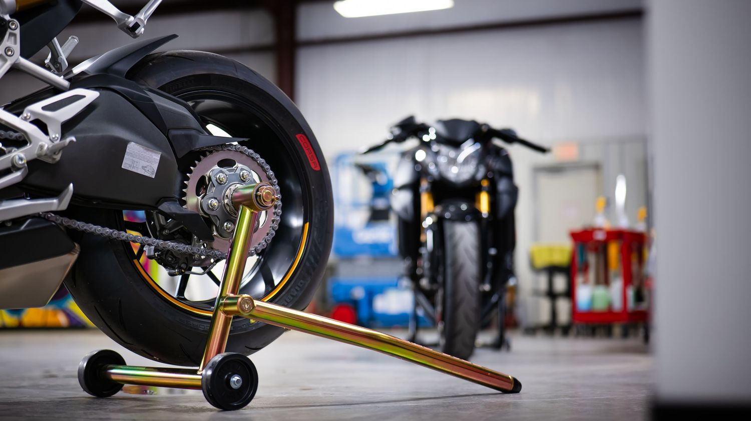 Wide angle view of a motorcycle workshop with tools and equipment.