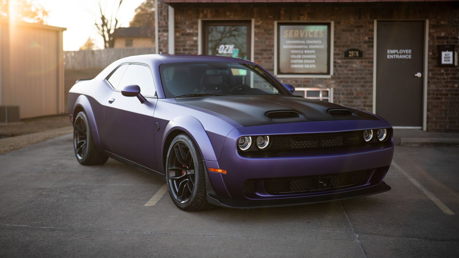 Custom Dodge Challenger showcasing aggressive styling in dramatic sunset lighting.