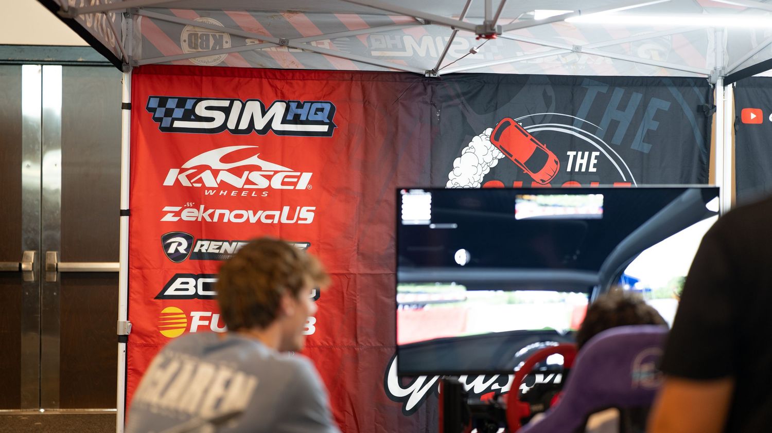 Row of sponsor banners and promotional signage displayed at an indoor event venue.