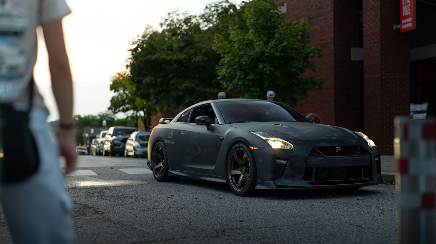 Low angle view of a city street with cars and buildings at sunset.