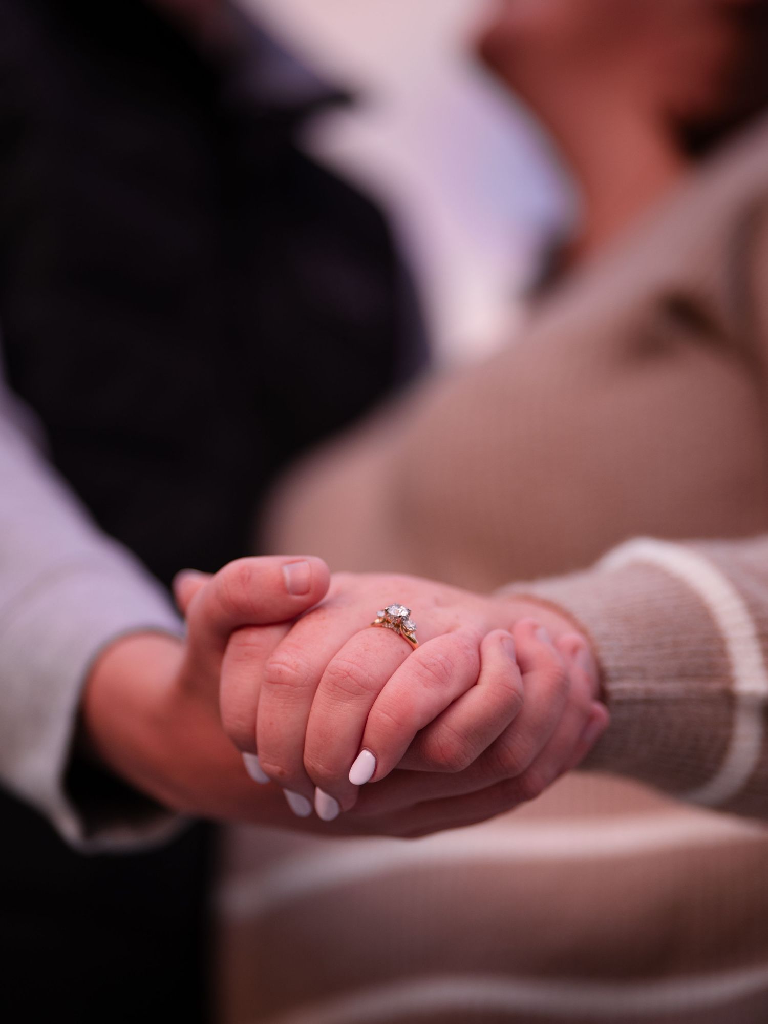 Close-up sequence of hands with white nail polish gently touching and interacting in a romantic gesture.