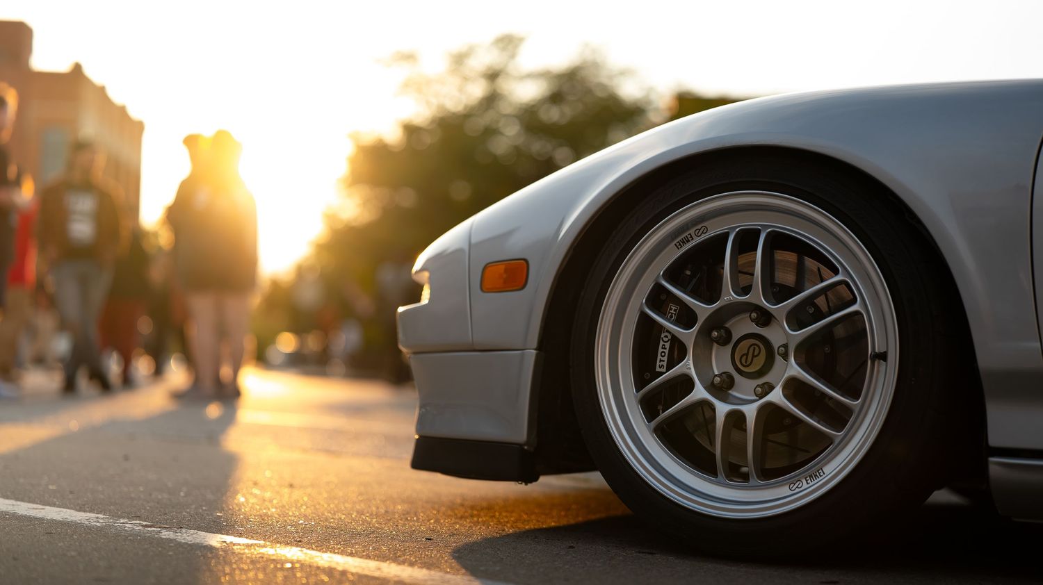 Close-up detail shots of sports car wheels and rims at sunset.