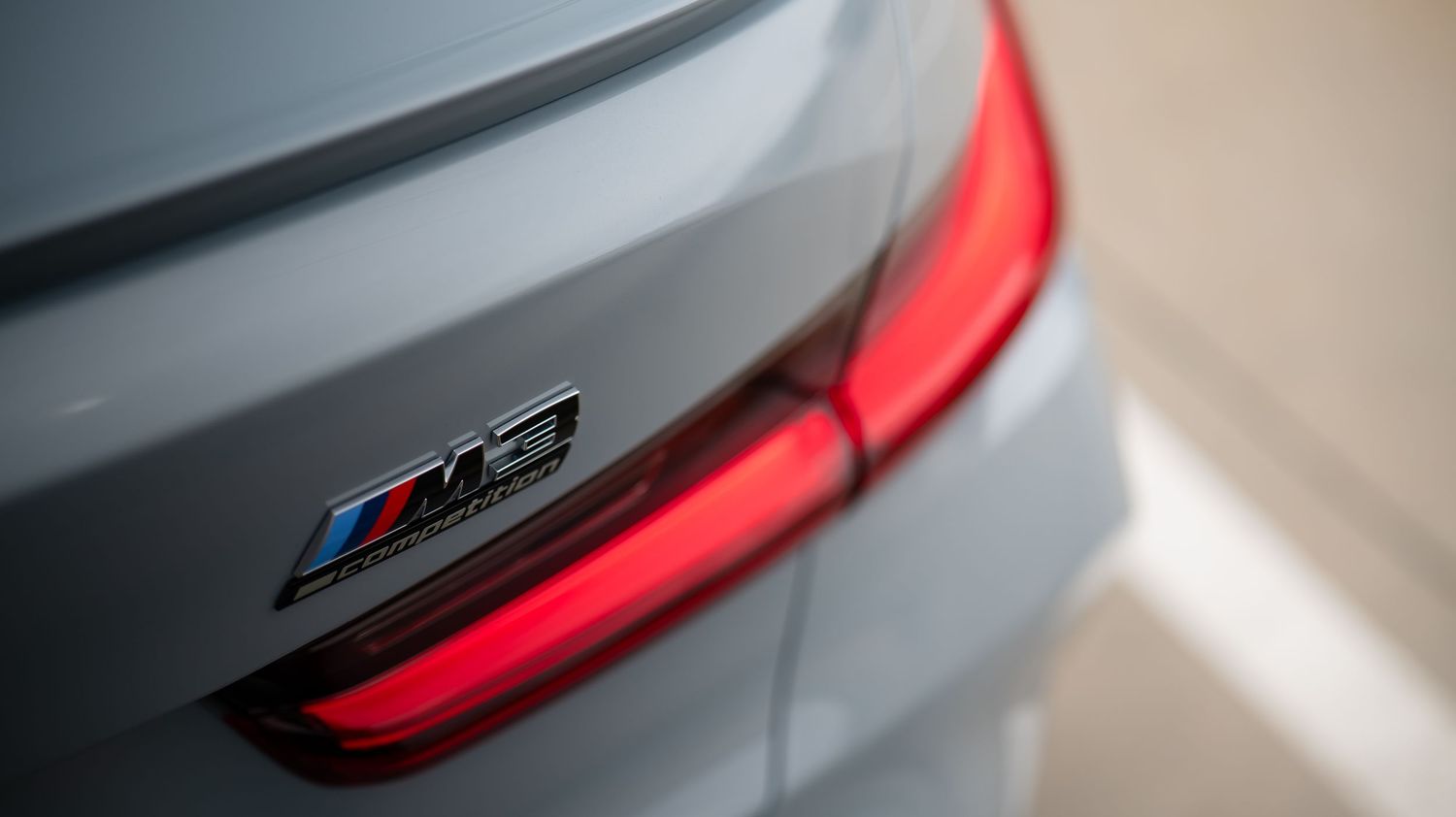 Close-up of red LED taillights on a gray sports car.