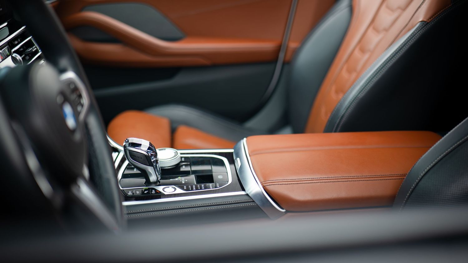 Luxury BMW interior featuring tan leather and modern center console design.