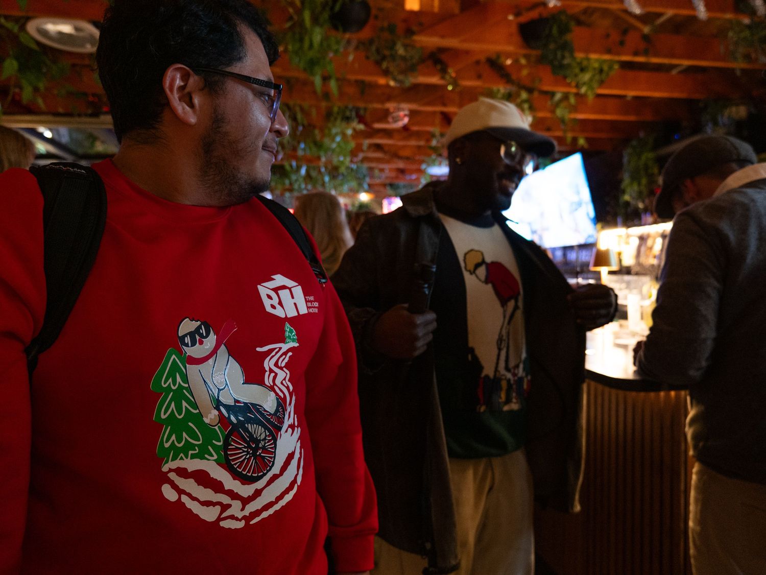 A group of people gathered in a dimly lit brick-walled bar or restaurant space.