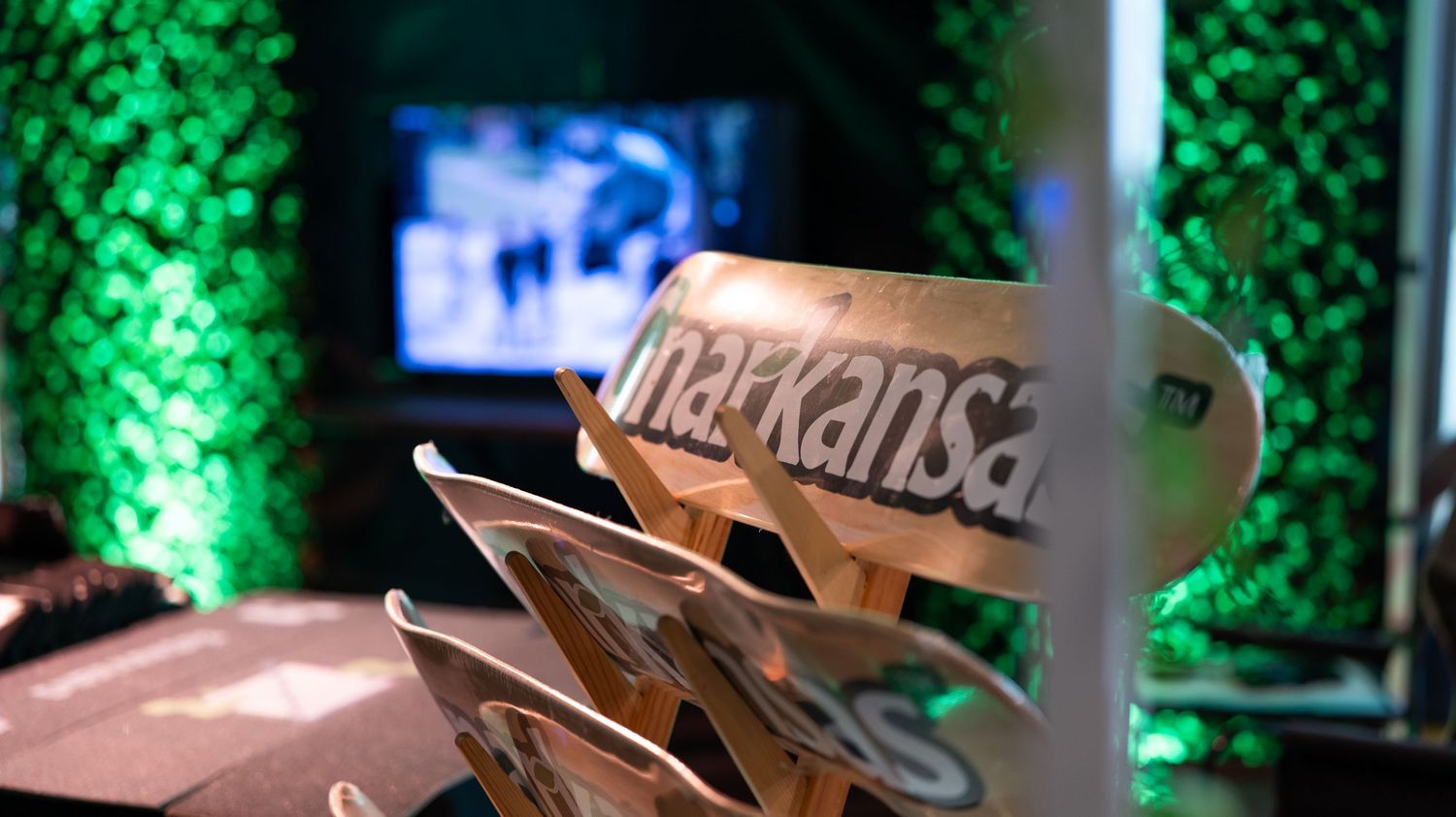 Event space decorated with green LED lighting and promotional displays.