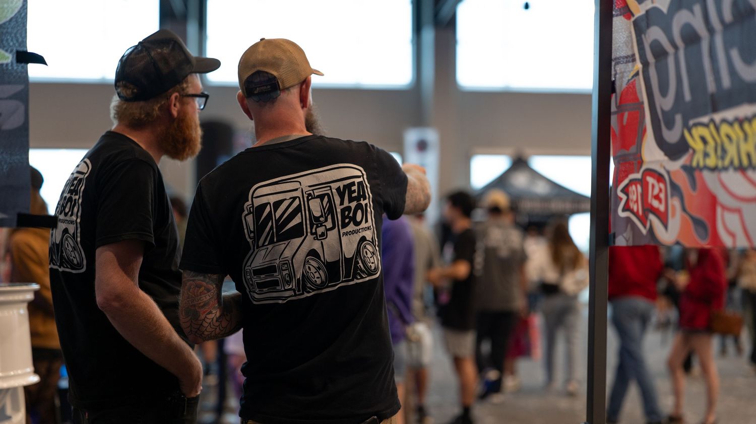 Crowd of attendees mingling at an indoor event space.