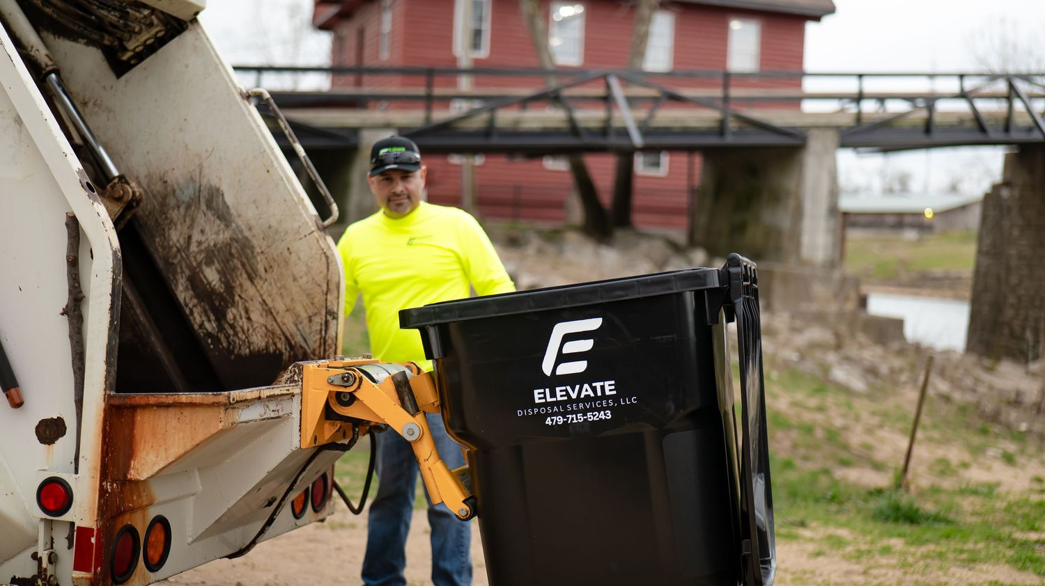 Commercial waste management operations with heavy equipment and workers in high visibility gear.