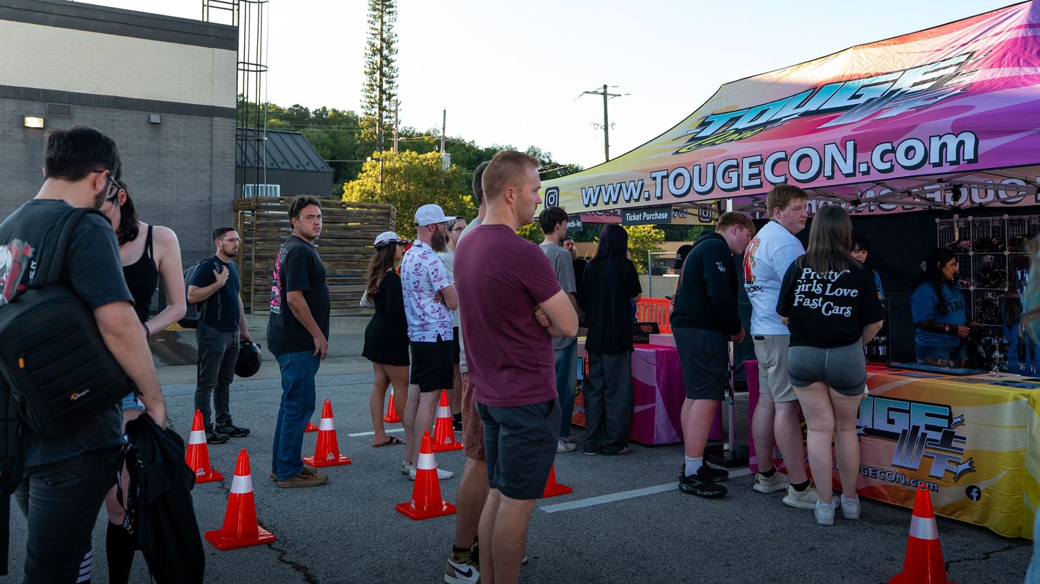 Outdoor event setup with vendor tents and traffic cones in a parking area.