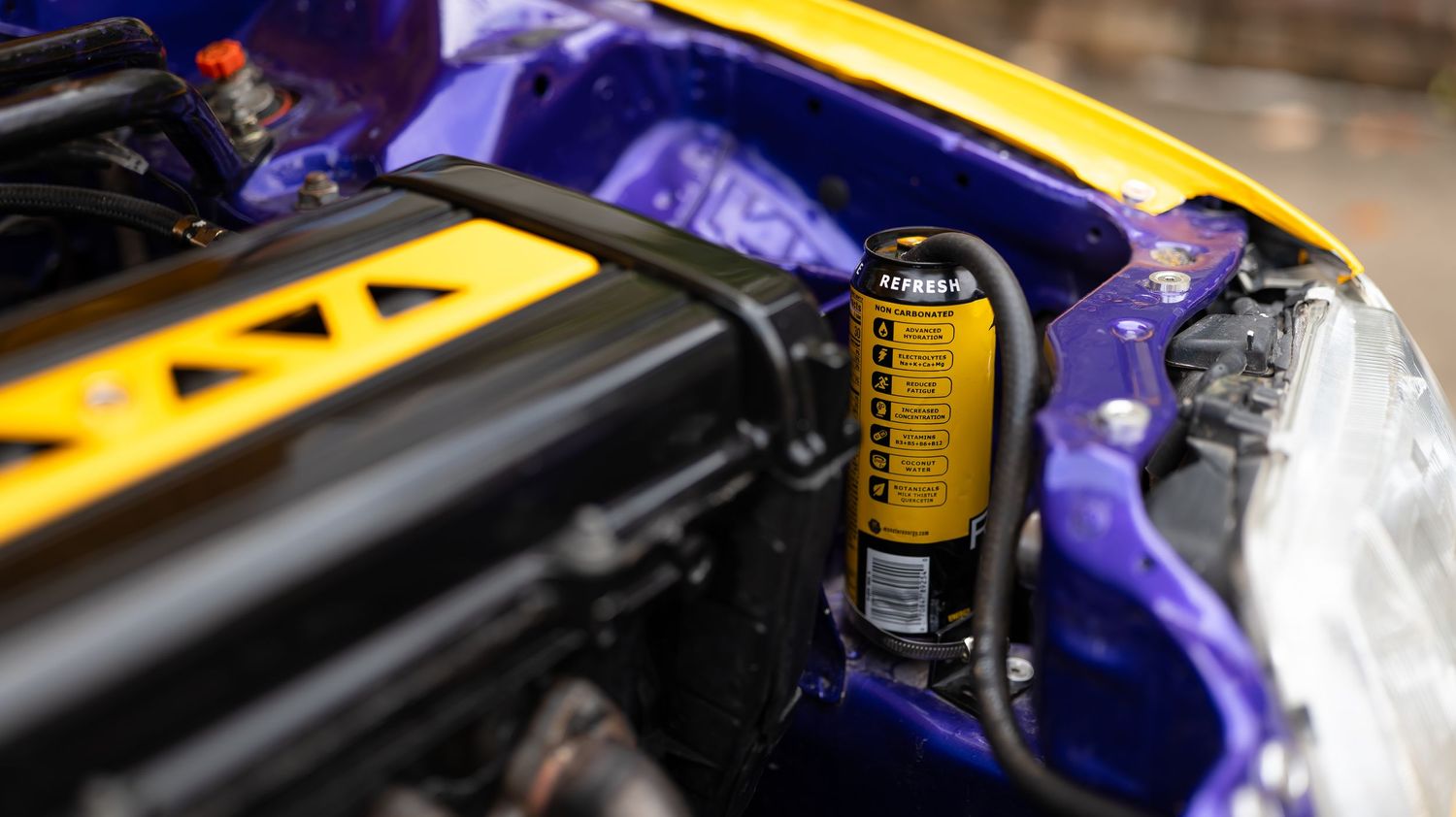 Close-up of performance car engine components and modifications under hood.