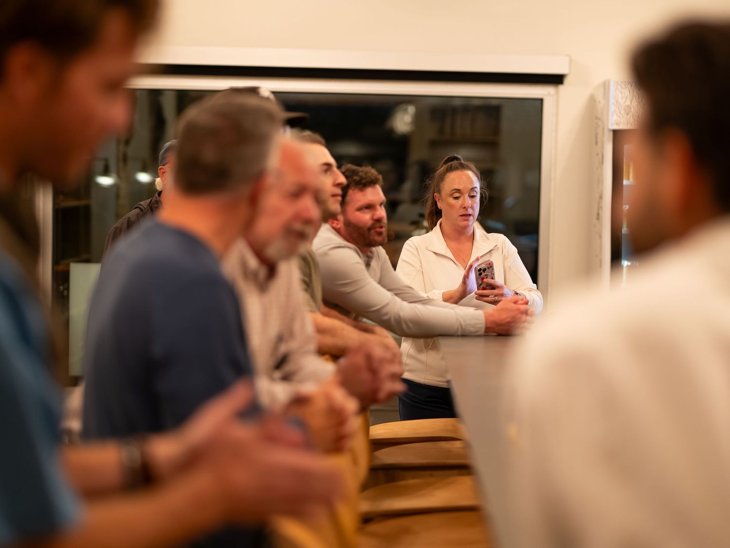 People gathered in a restaurant dining room enjoying a meal and conversation together.
