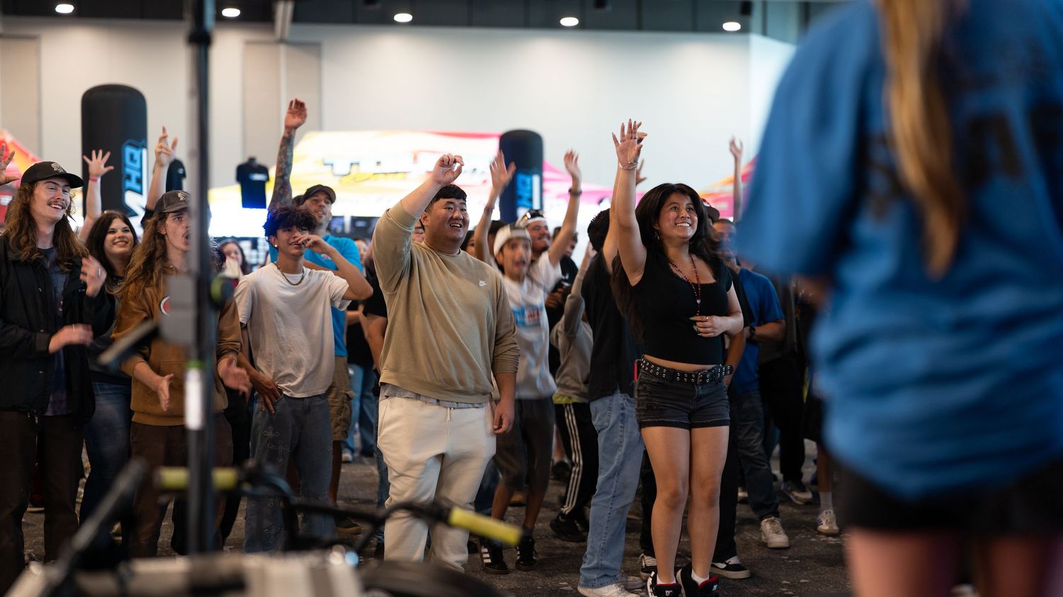 Crowd of attendees gathering in a large indoor venue space during an event.