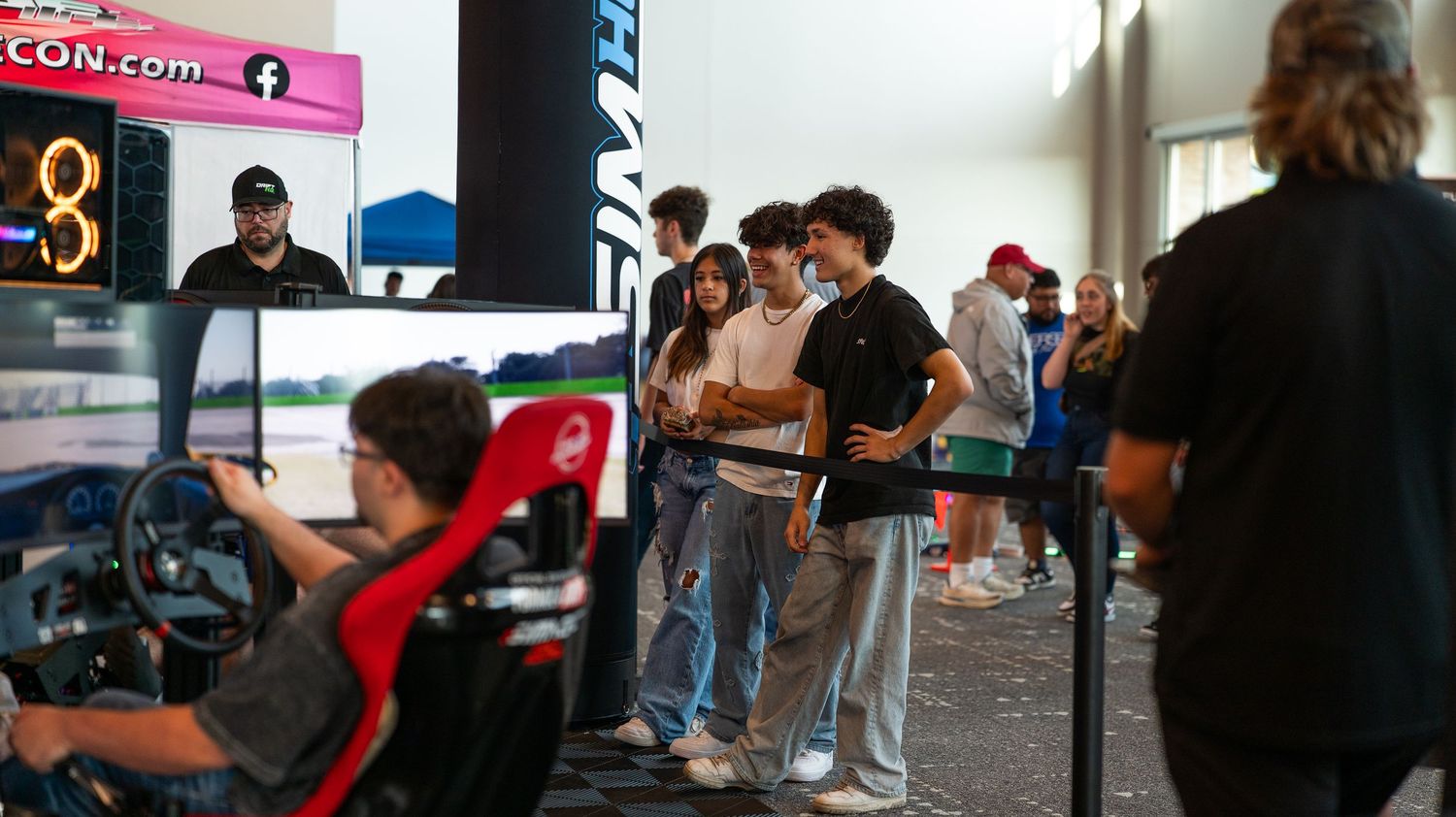 Convention hall filled with attendees browsing gaming merchandise and displays.
