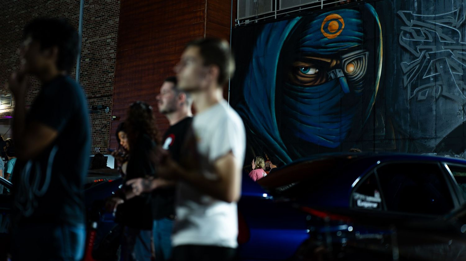 Dark indoor venue with blue accent lighting and event displays.
