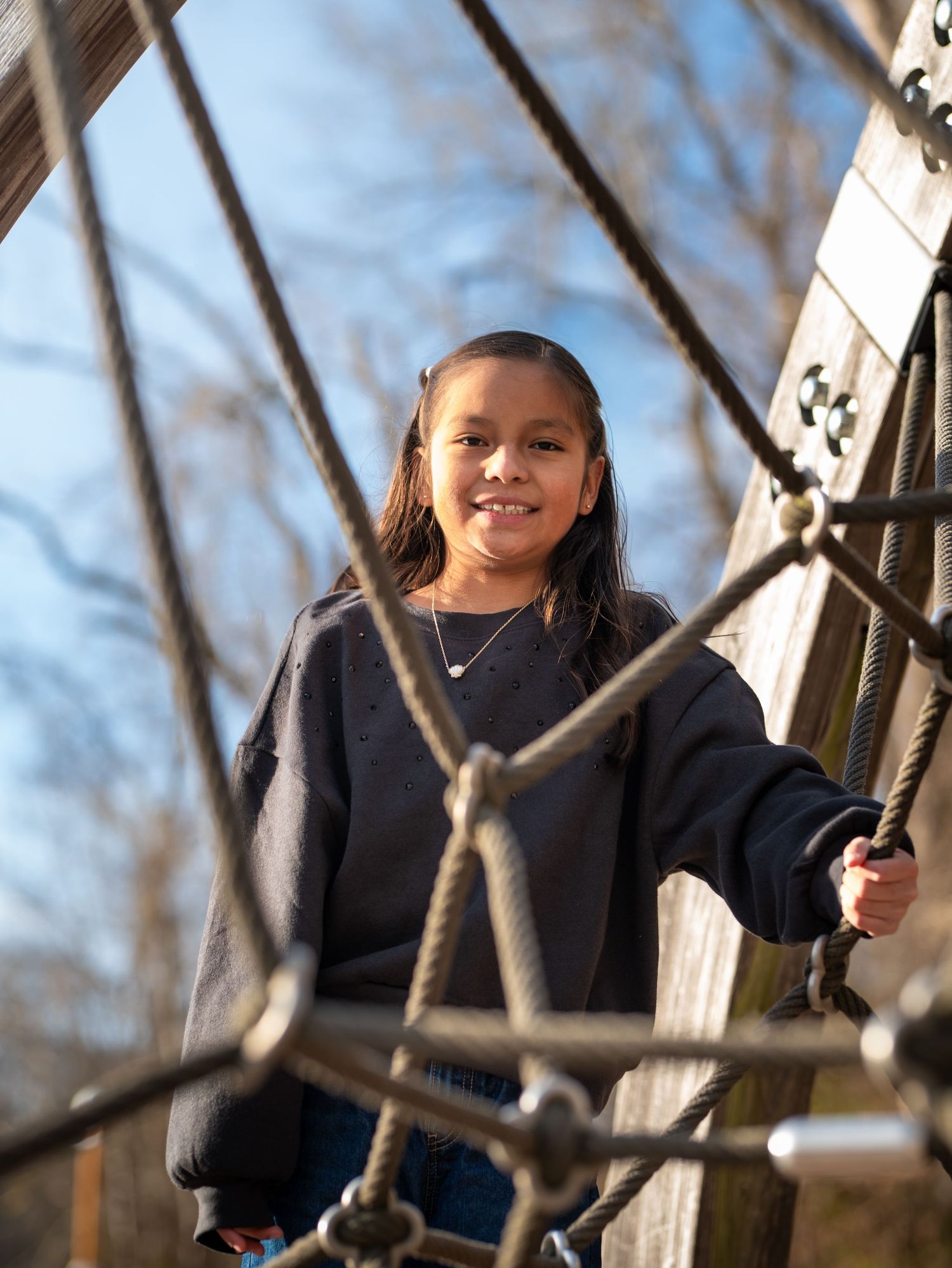 A sequence of photos shows someone in a navy sweater swinging outdoors on a winter day with tree branches visible.