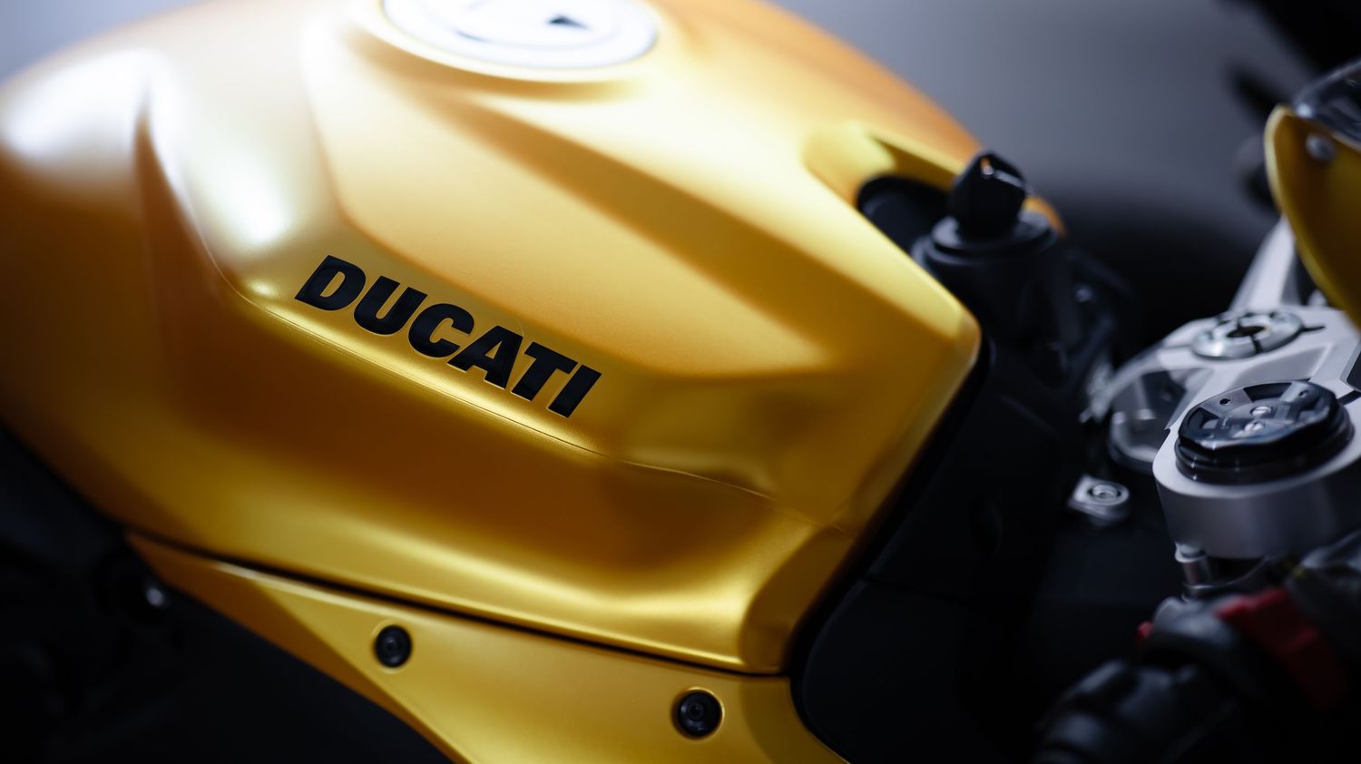 Close-up of yellow Ducati motorcycle tank and bodywork details.