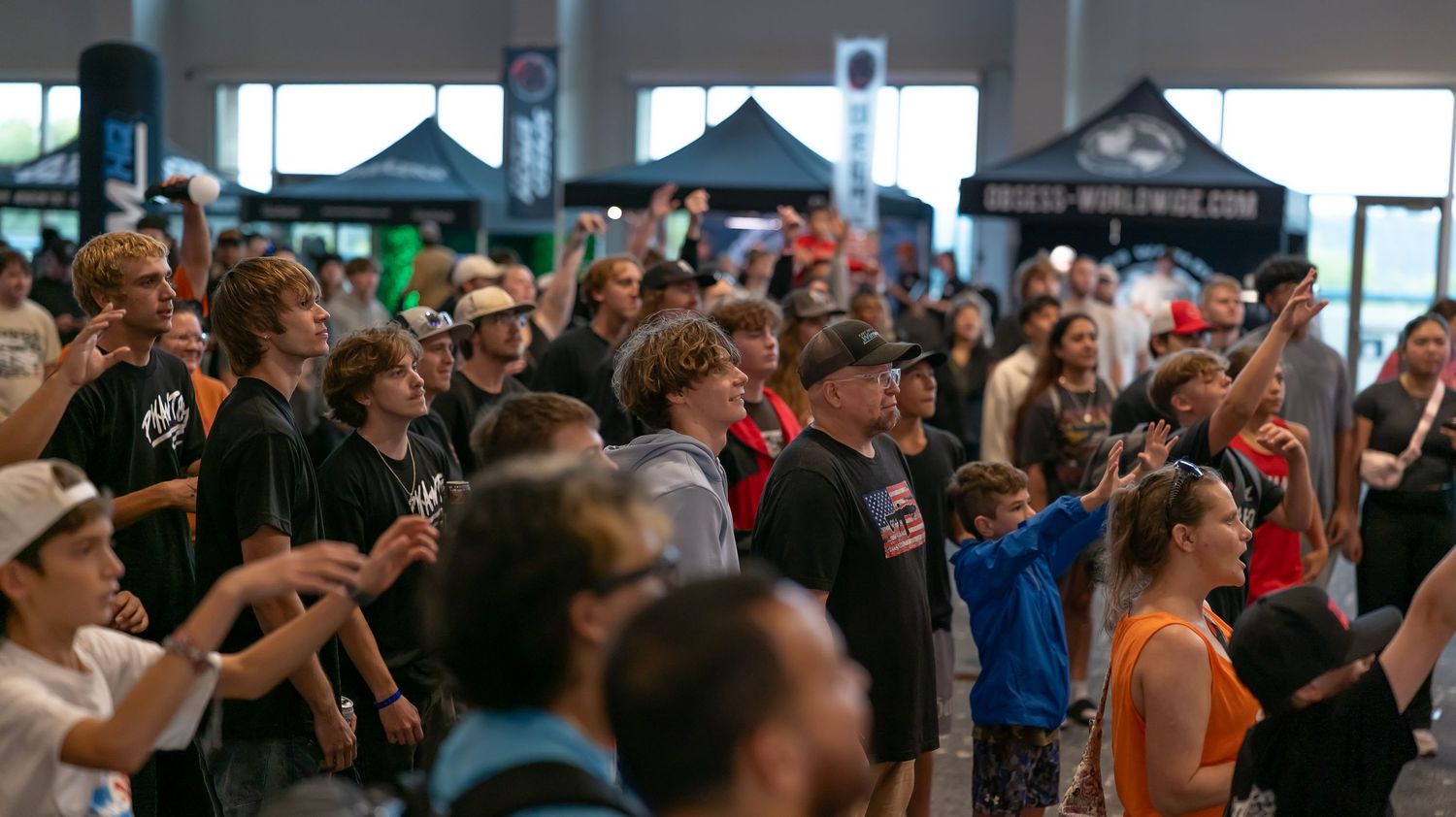 Dense crowd of spectators gathered at an indoor event space.