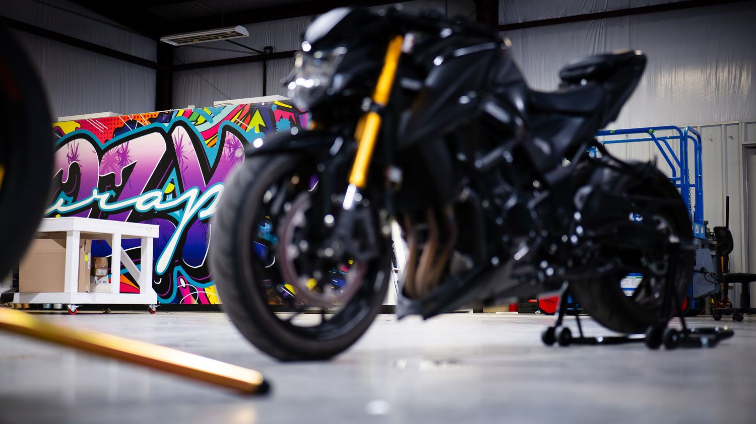 Custom motorcycles lined up in a dark showroom with dramatic lighting effects.