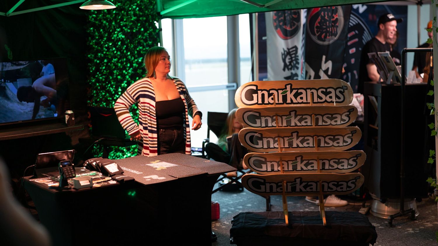 Green decorative elements and signage visible in an indoor venue space.