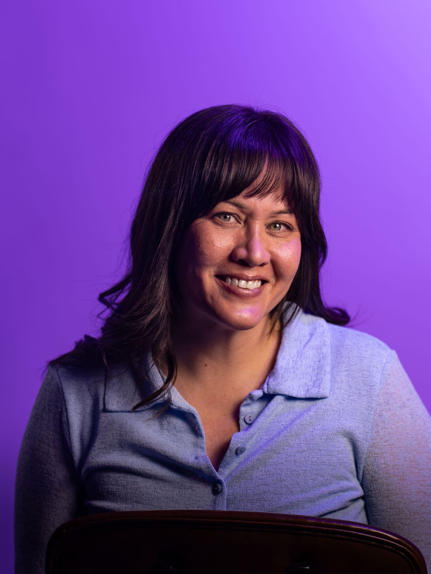 A series of five headshots against a purple background showing expressions transitioning from neutral to joyful.