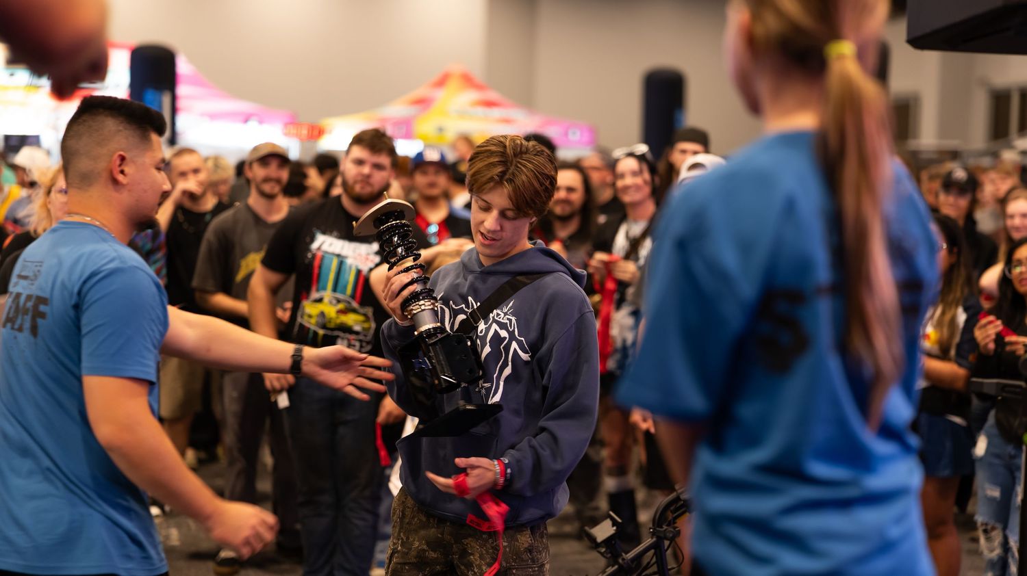 Crowd of attendees in casual attire gathered at indoor gaming event.