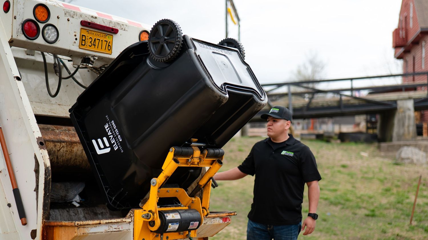 Heavy duty waste management equipment being operated in an outdoor setting.