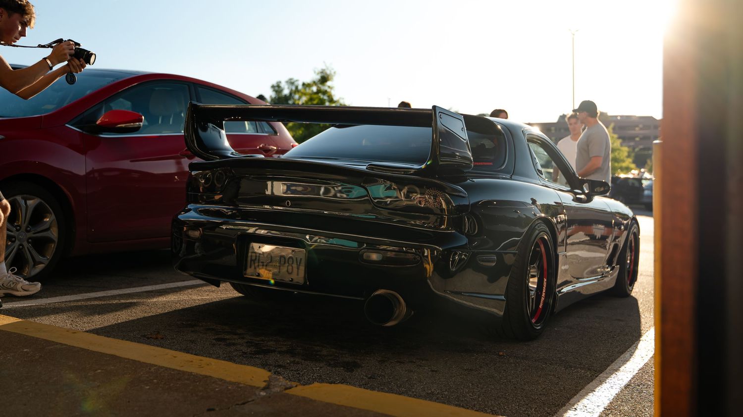Classic cars and sports vehicles lined up at an outdoor auto show.
