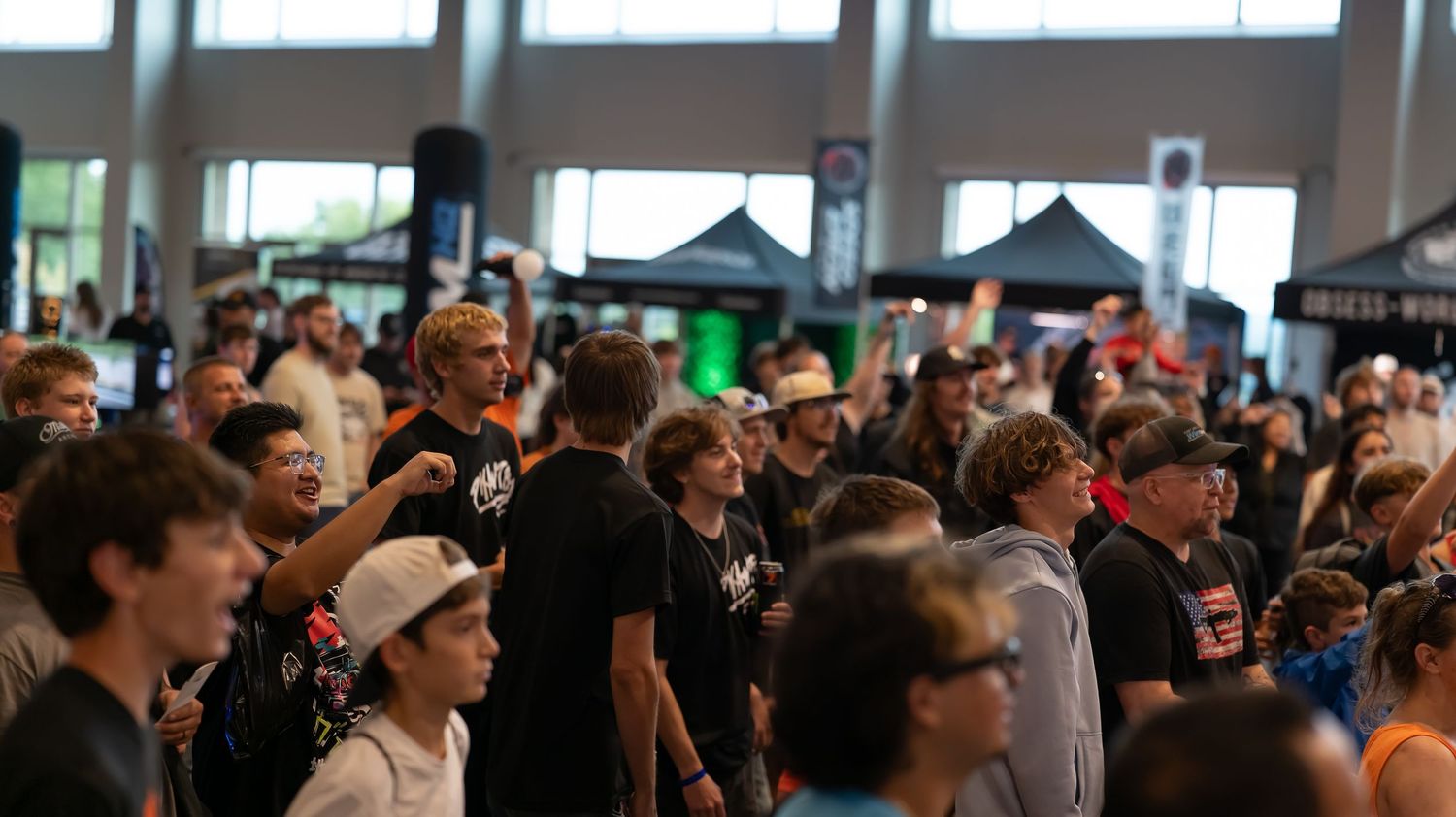 Crowded indoor event space filled with spectators watching a performance.
