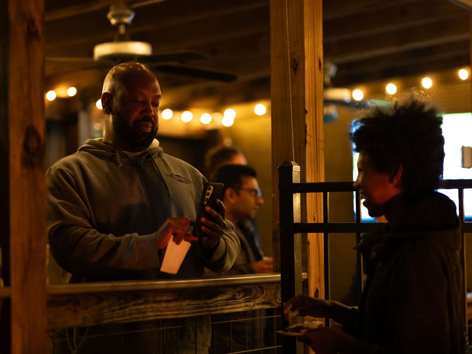 A dimly lit restaurant interior with warm lighting and wooden beams creates an intimate dining atmosphere.